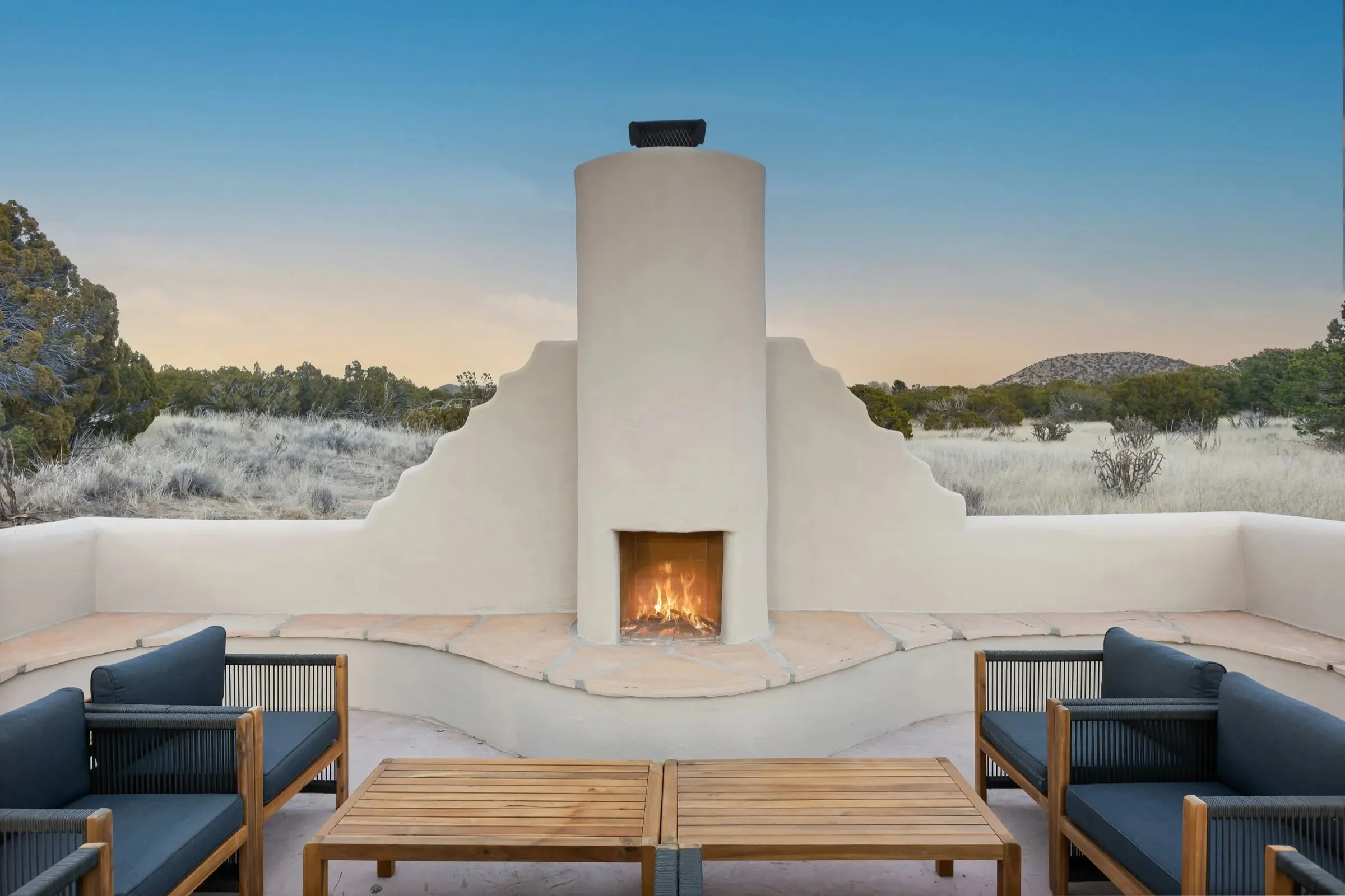 The outdoor kiva fireplace lounge at Casa de Camino, at sunset