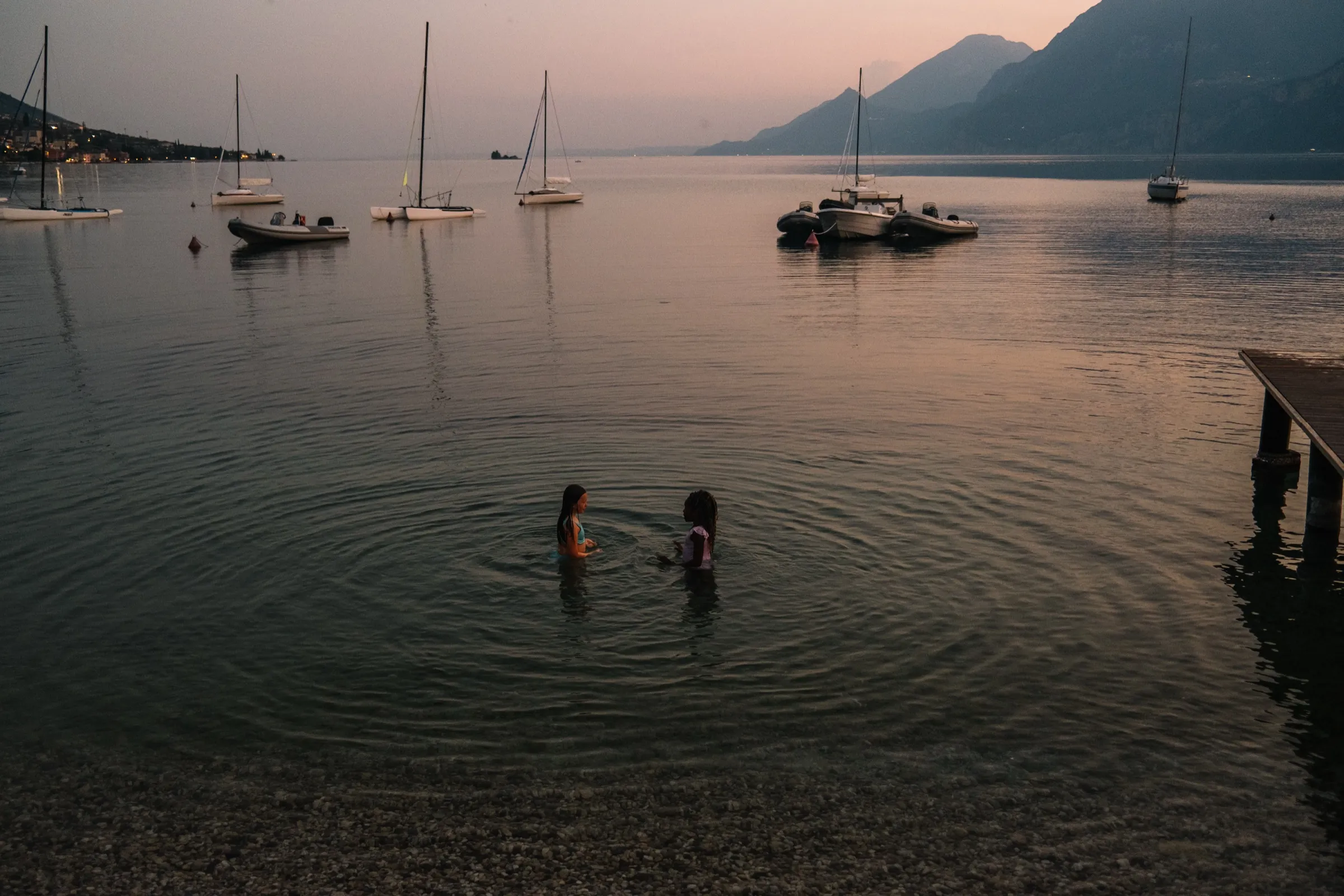 The Ice kids wading into a lake at dusk