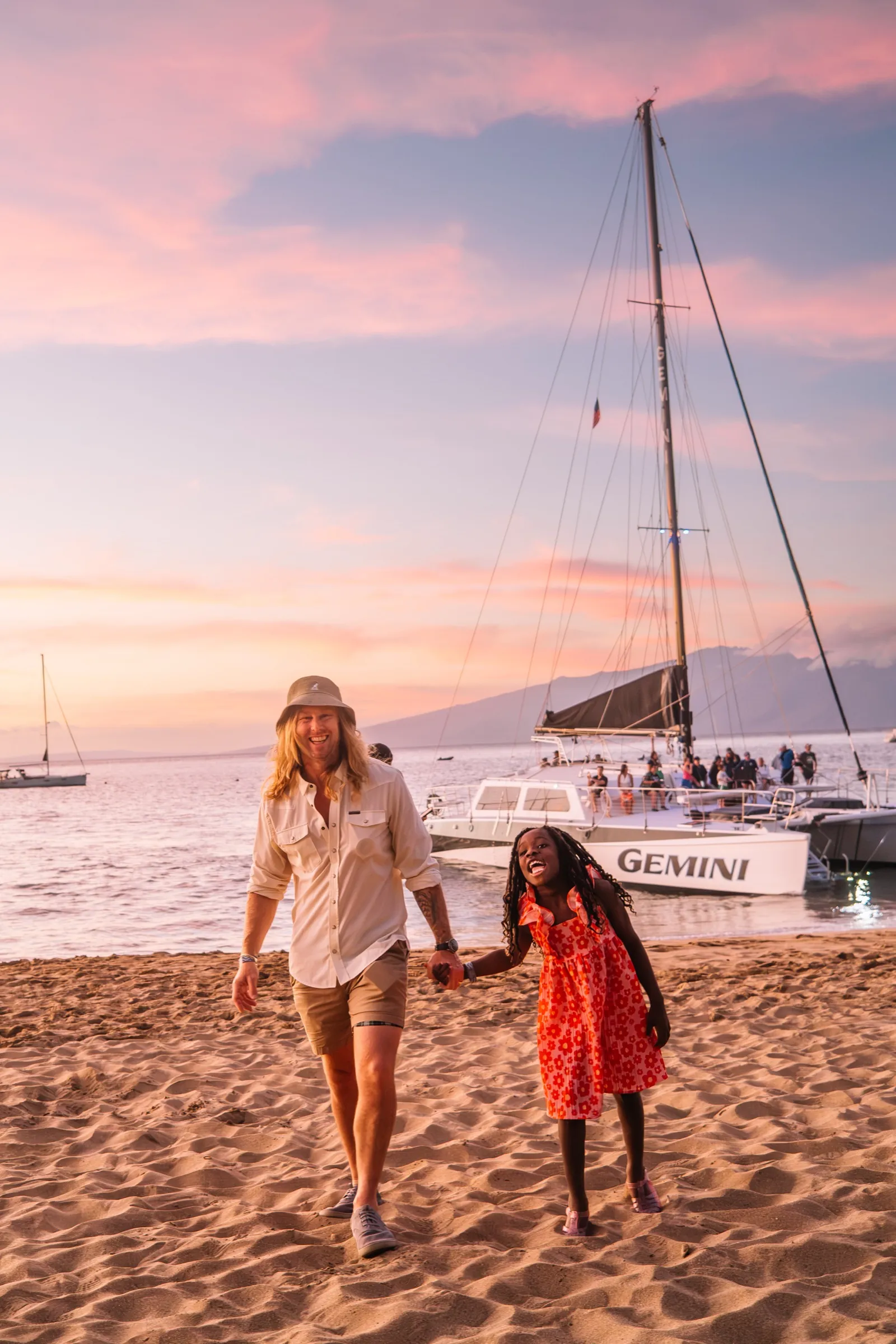 Walking out the last of the light on the beach, catamaran behind