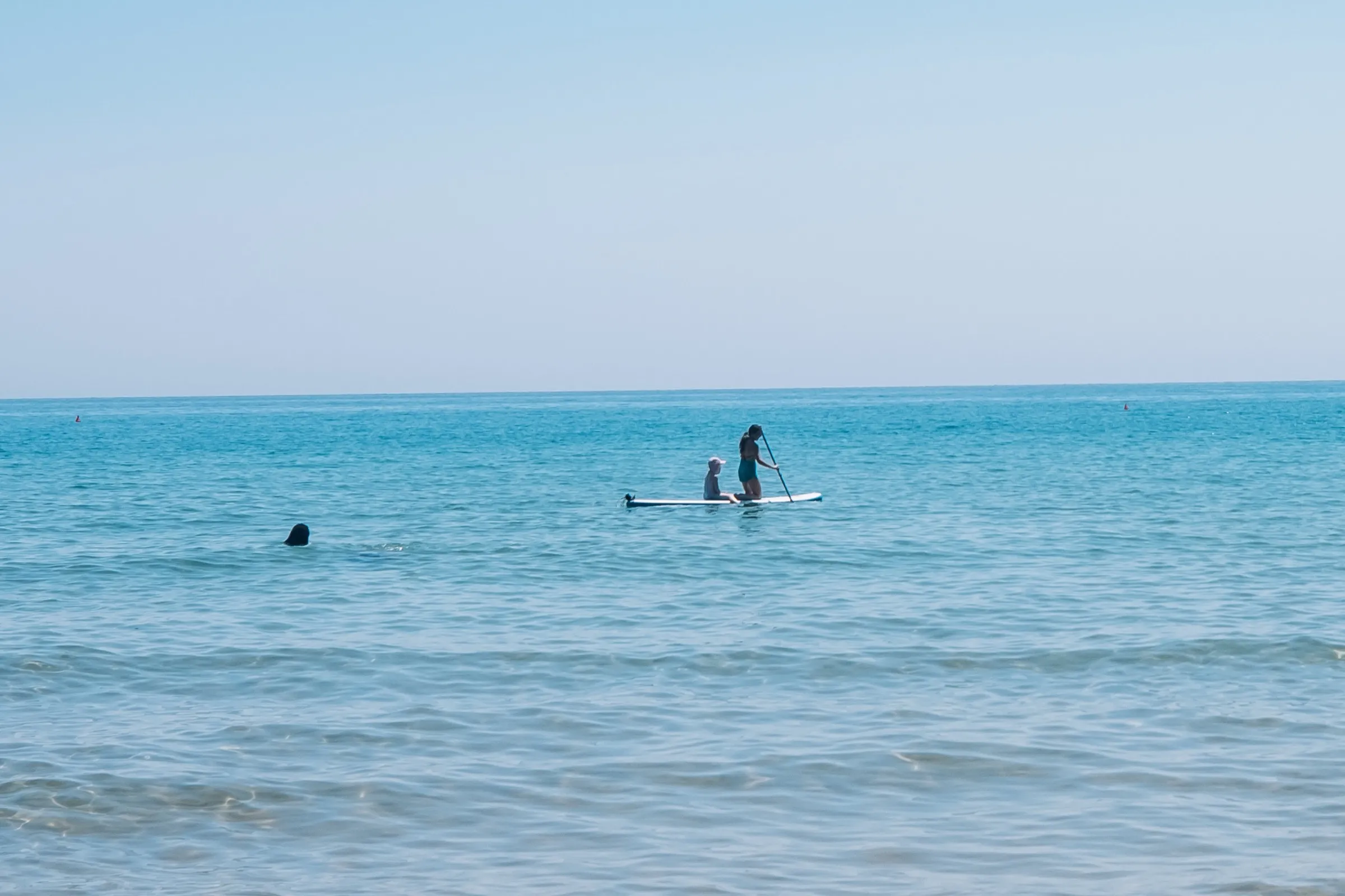 A lone paddleboarder on the calm morning sea off Gaeta