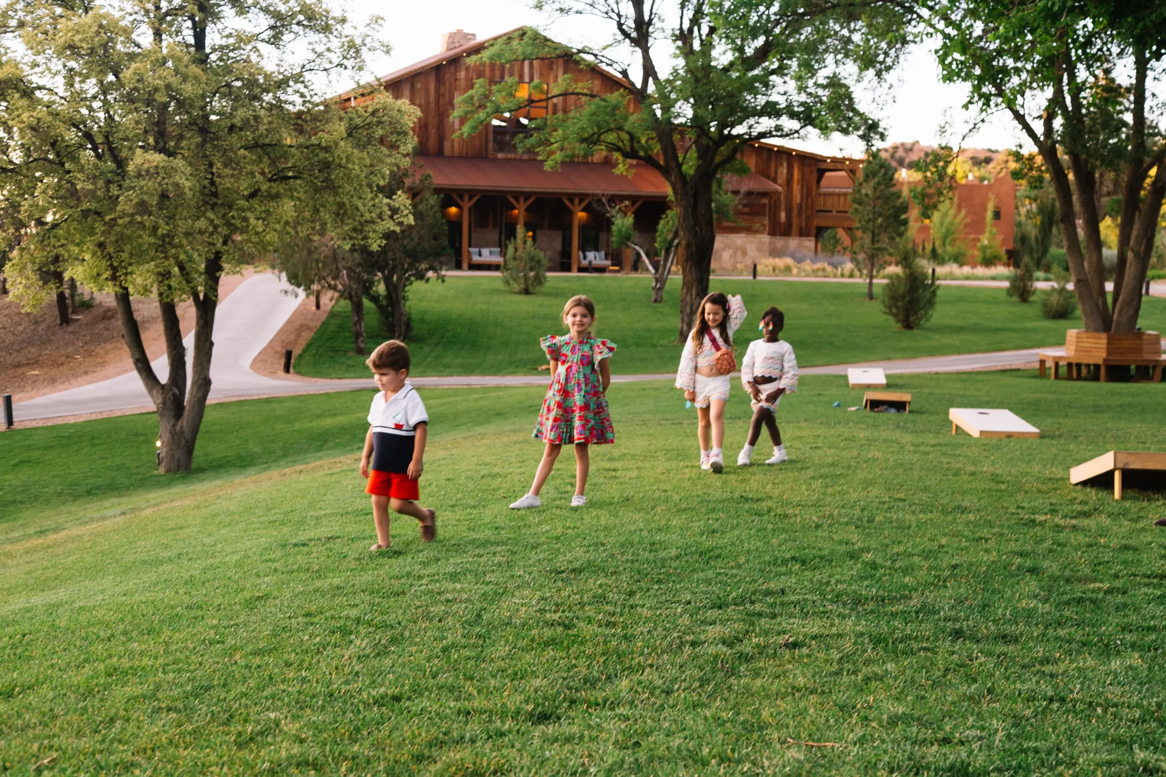 An adobe lodge at golden hour, the Ice family out on the grounds