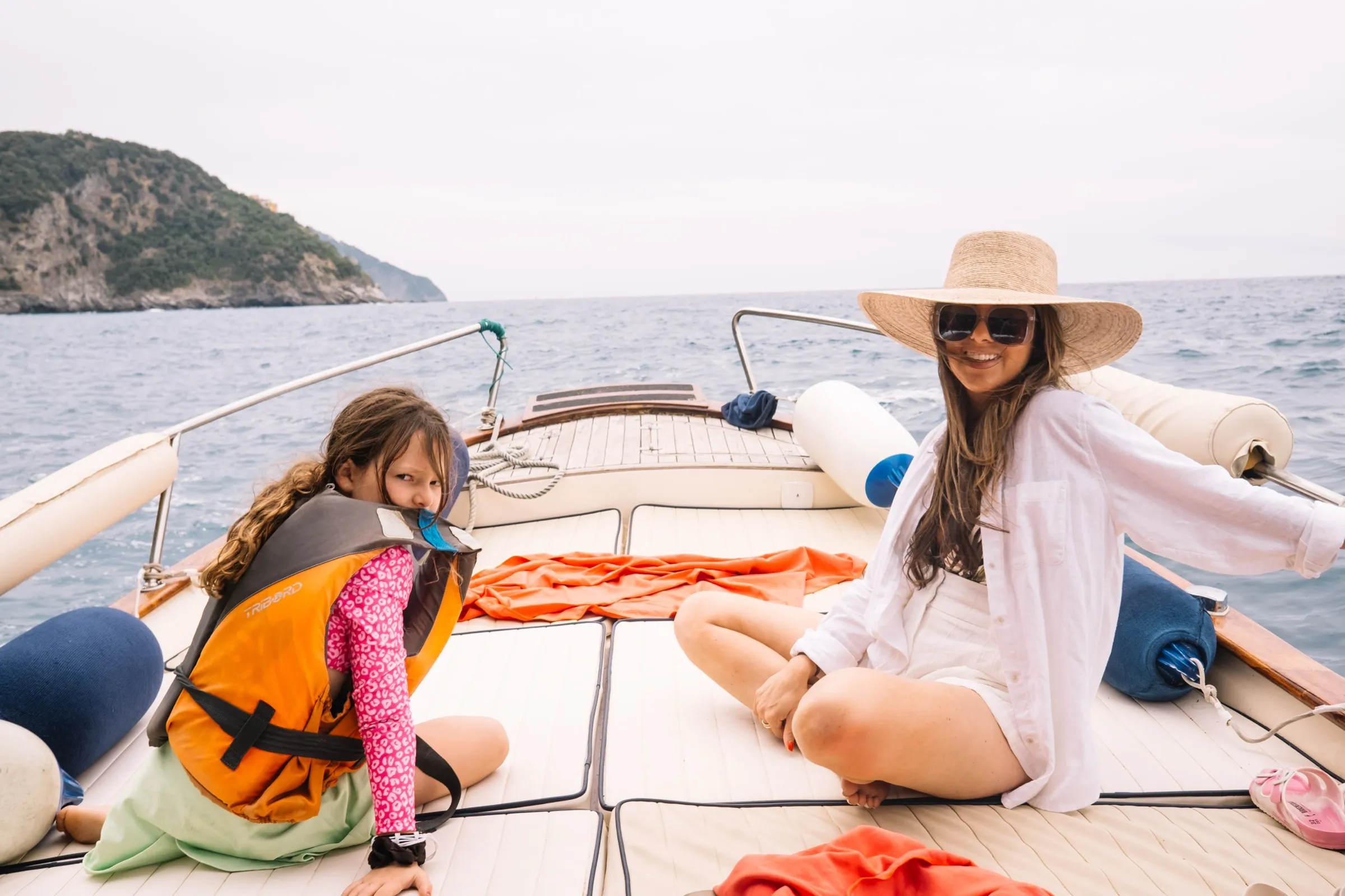 Melissa and Rosie, in a life vest, on the wooden deck of a tour boat off the Cinque Terre coast