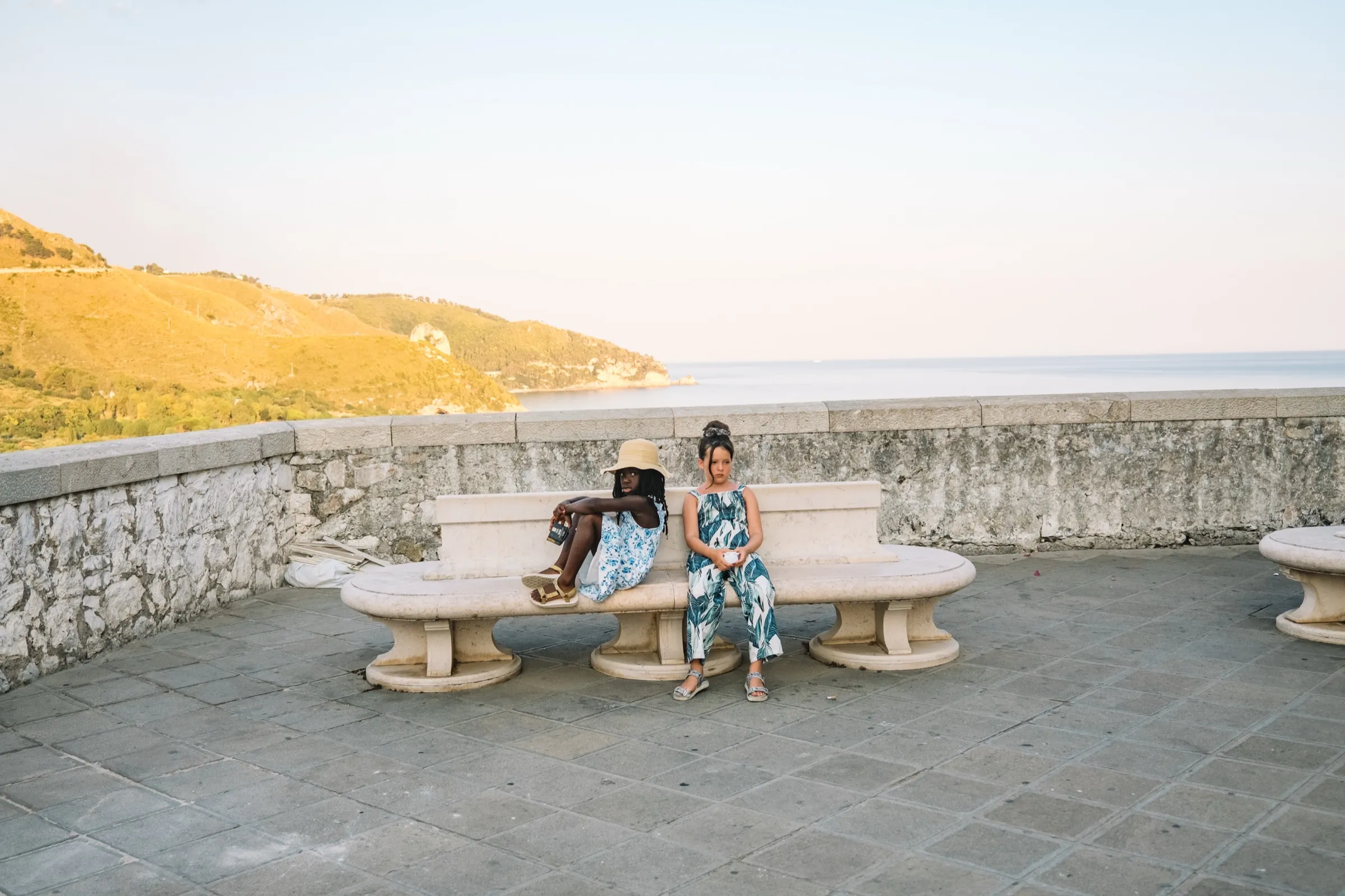 A golden-hour sea overlook in Sperlonga, a table set above the water